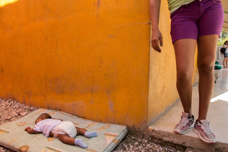 A mother looks on as her baby sleeps at Albergue La 72 in Tenosique, Tabasco. Photo by Gabriela Bortolamedi.